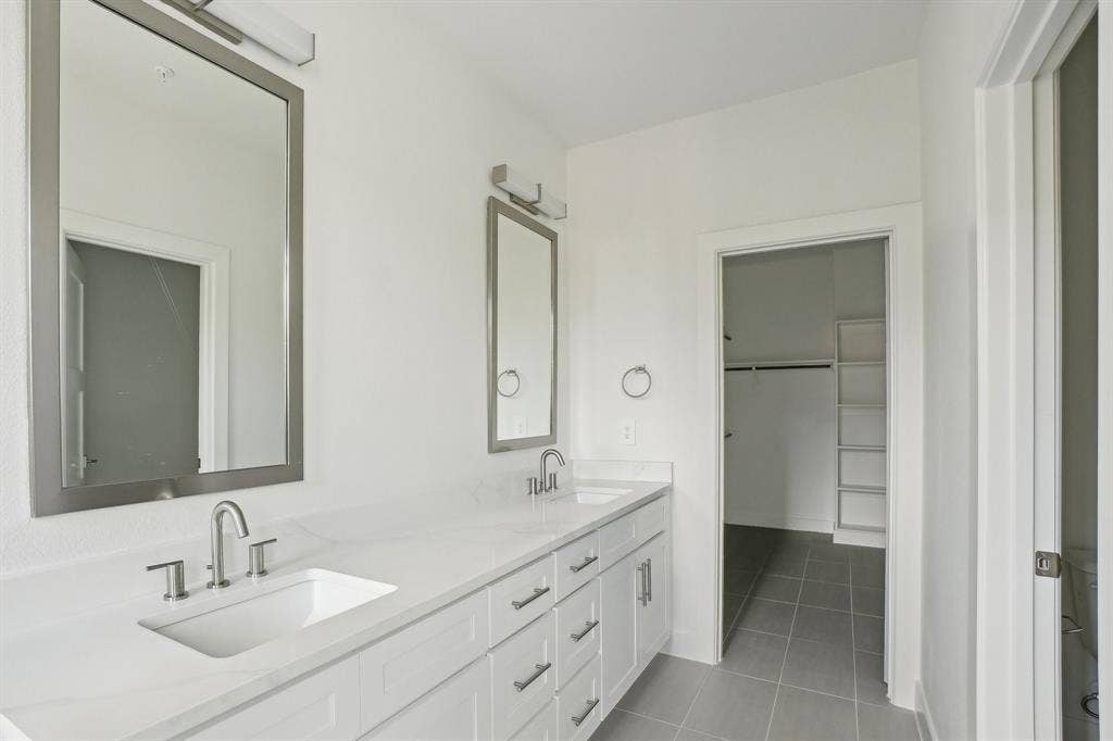 2524 Havenhurst Street, #102, Farmers Branch, TX 75234 Bathroom featuring double vanity, a spacious closet, and light tile patterned floors