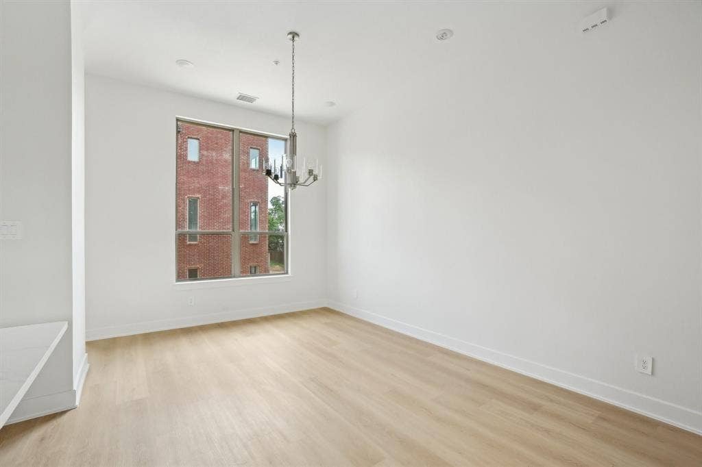 2524 Havenhurst Street, #102, Farmers Branch, TX 75234 Unfurnished room featuring light wood-type flooring and a chandelier