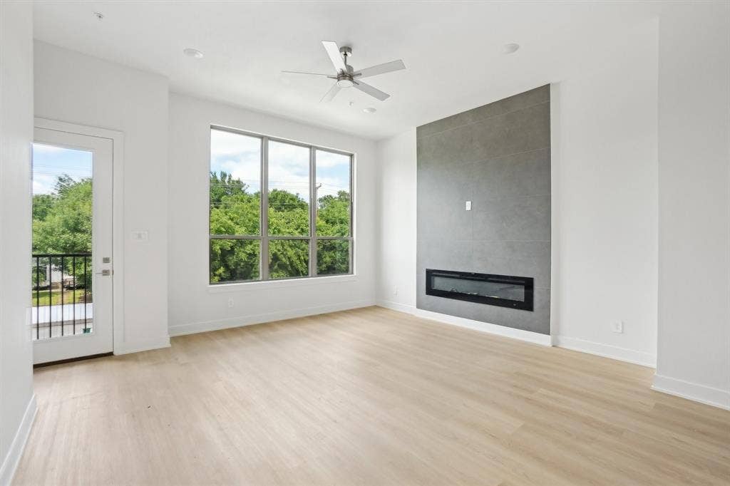 2524 Havenhurst Street, #102, Farmers Branch, TX 75234 Unfurnished living room with a tile fireplace, light wood-style floors, and ceiling fan