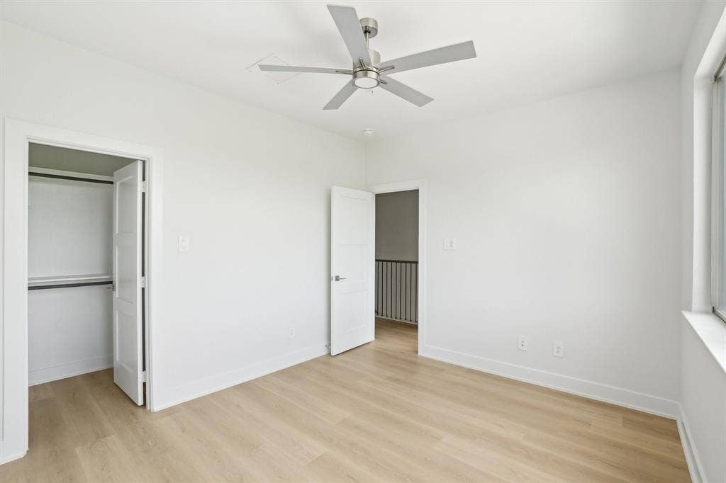 2524 Havenhurst Street, #102, Farmers Branch, TX 75234 Unfurnished bedroom with light wood finished floors, a ceiling fan, and a spacious closet