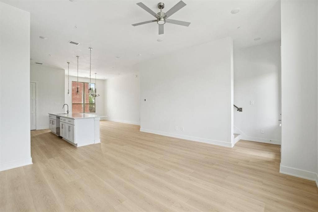 2524 Havenhurst Street, #102, Farmers Branch, TX 75234 Unfurnished living room featuring light wood-style flooring, ceiling fan, and stairway