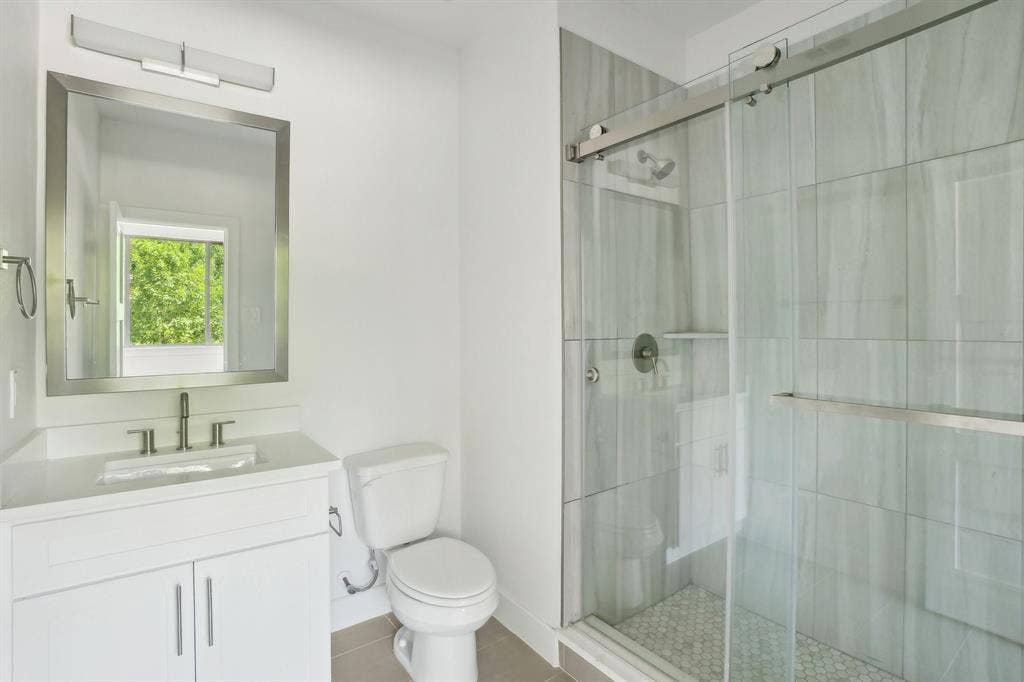 2524 Havenhurst Street, #102, Farmers Branch, TX 75234 Bathroom with vanity, a shower stall, and light tile patterned floors