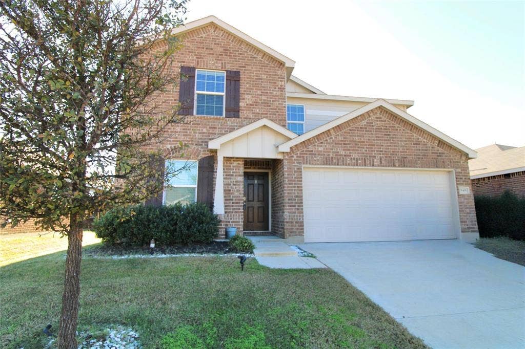 Traditional-style home with brick siding, concrete driveway, a front lawn, and a garage