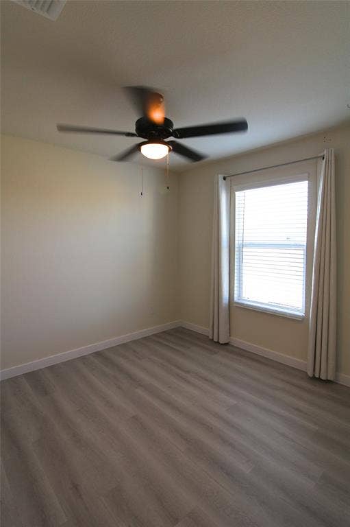 Spare room featuring wood finished floors and ceiling fan
