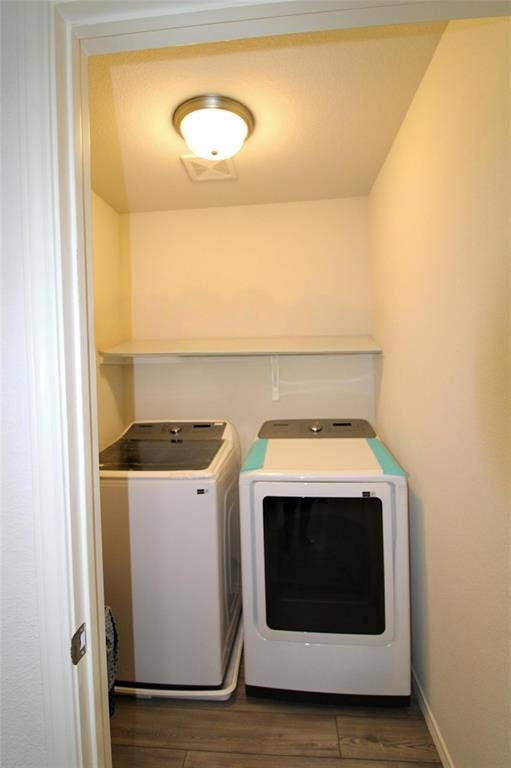 Laundry area with dark wood-style flooring and washer and dryer