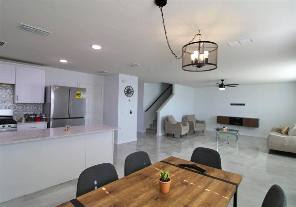 Dining area featuring a ceiling fan, stairway, a chandelier, and recessed lighting