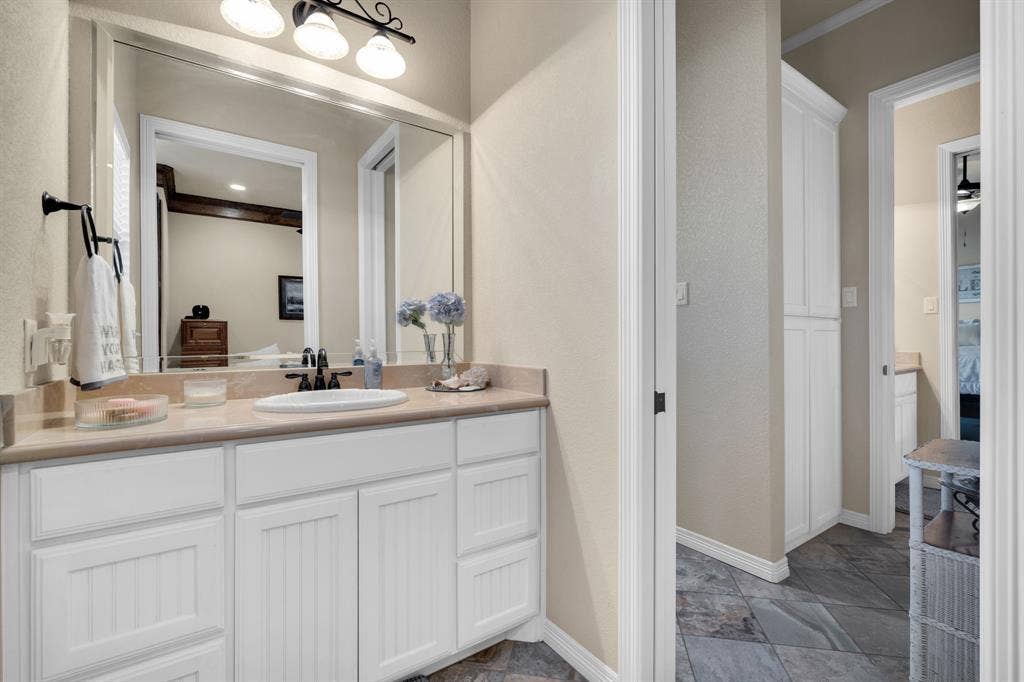 217 Hunter Pass, Waxahachie, TX 75165 Bathroom with ensuite bathroom, vanity, and stone tile flooring