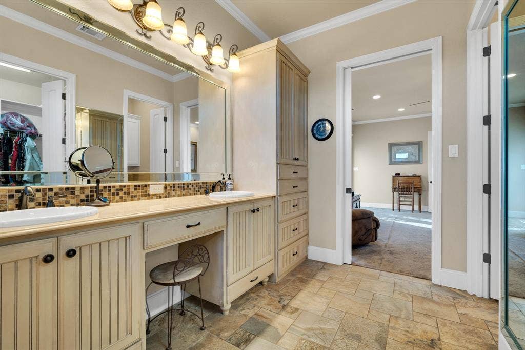 217 Hunter Pass, Waxahachie, TX 75165 Full bath with crown molding, stone tile floors, double vanity, tasteful backsplash, and a walk in closet
