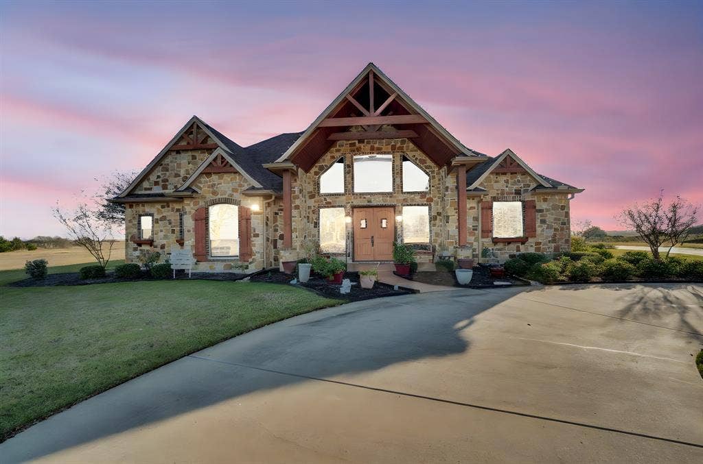 217 Hunter Pass, Waxahachie, TX 75165 View of front of property with stone siding and a yard
