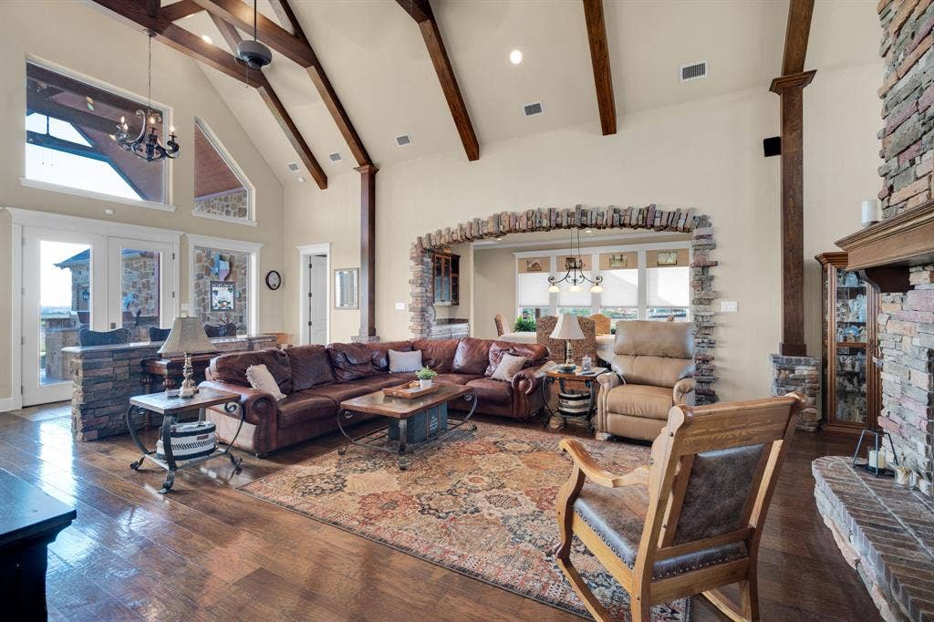 217 Hunter Pass, Waxahachie, TX 75165 Living area with a chandelier, high vaulted ceiling, a fireplace with raised hearth, recessed lighting, and dark wood-type flooring