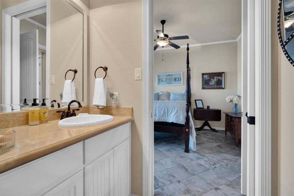 217 Hunter Pass, Waxahachie, TX 75165 Ensuite bathroom with vanity, crown molding, stone finish flooring, and a ceiling fan