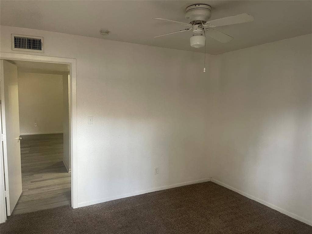 322 S Waco Street, Weatherford, TX 76086 Unfurnished room featuring ceiling fan and dark carpet