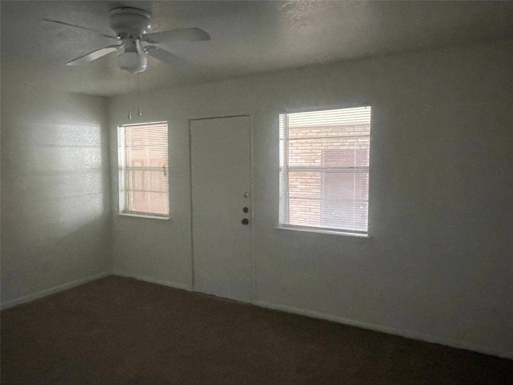 322 S Waco Street, Weatherford, TX 76086 Empty room with healthy amount of natural light and a ceiling fan