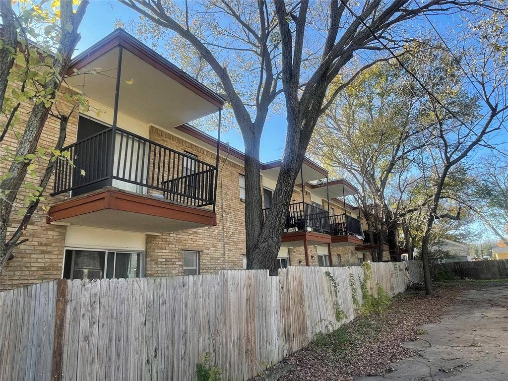 322 S Waco Street, Weatherford, TX 76086 View of side of home with a balcony and brick siding