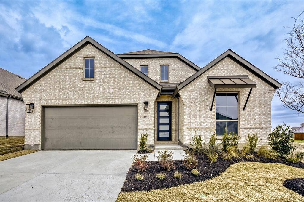 2228 Prickly Cactus Drive, Forney, TX 75126 View of front facade with concrete driveway, a garage, and brick siding