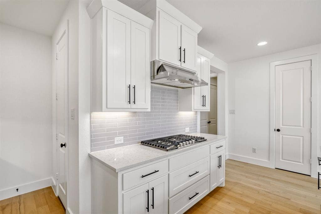 2228 Prickly Cactus Drive, Forney, TX 75126 Kitchen with white cabinets, light stone countertops, light wood-type flooring, recessed lighting, and stainless steel gas stovetop