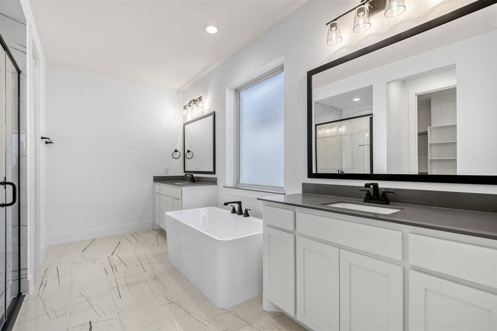 2228 Prickly Cactus Drive, Forney, TX 75126 Bathroom featuring a soaking tub, two vanities, a marble finish shower, recessed lighting, and light marble finish flooring