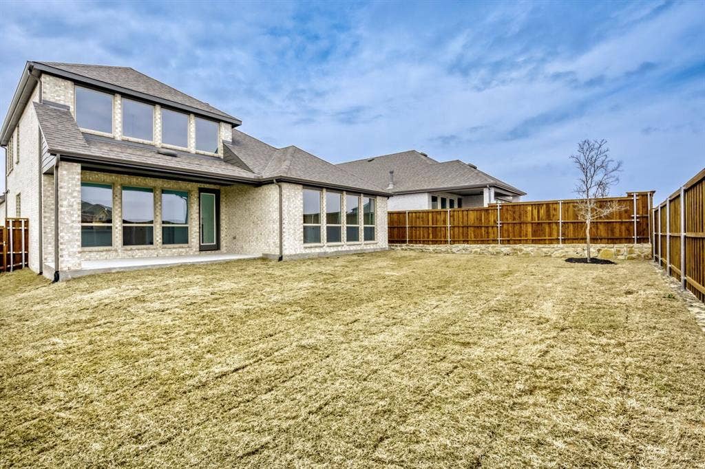 2228 Prickly Cactus Drive, Forney, TX 75126 Rear view of house with a fenced backyard, brick siding, a patio area, and a shingled roof