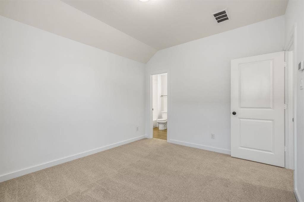 2228 Prickly Cactus Drive, Forney, TX 75126 Unfurnished bedroom featuring carpet flooring, lofted ceiling, and ensuite bathroom