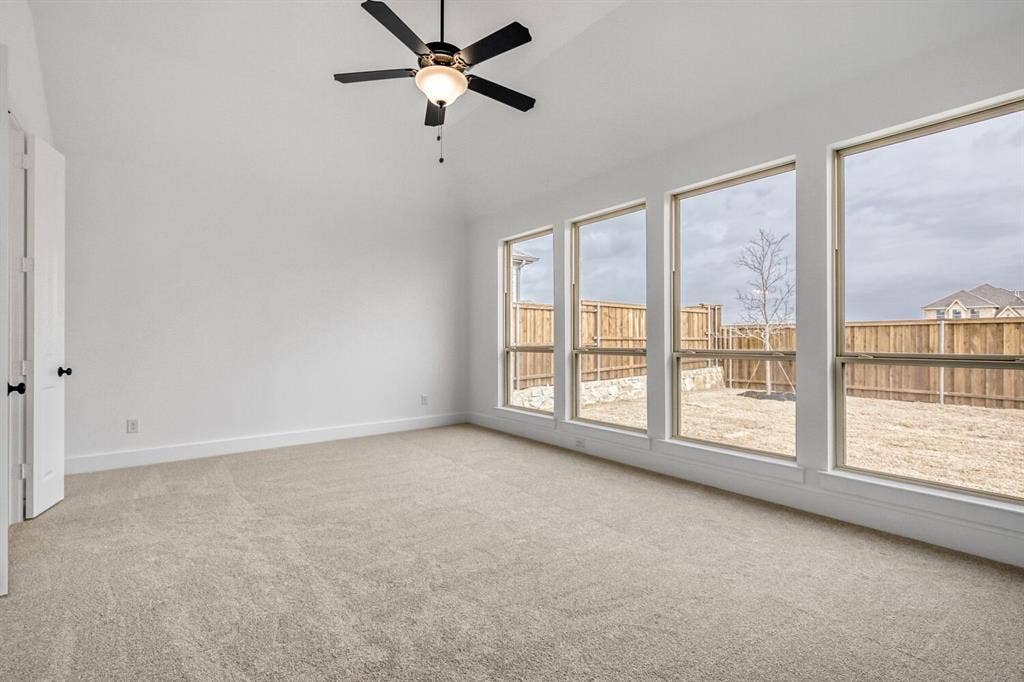2228 Prickly Cactus Drive, Forney, TX 75126 Empty room featuring ceiling fan, light carpet, and vaulted ceiling