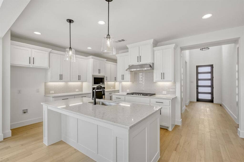 2228 Prickly Cactus Drive, Forney, TX 75126 Kitchen featuring white cabinets, light wood-type flooring, light stone countertops, and pendant lighting