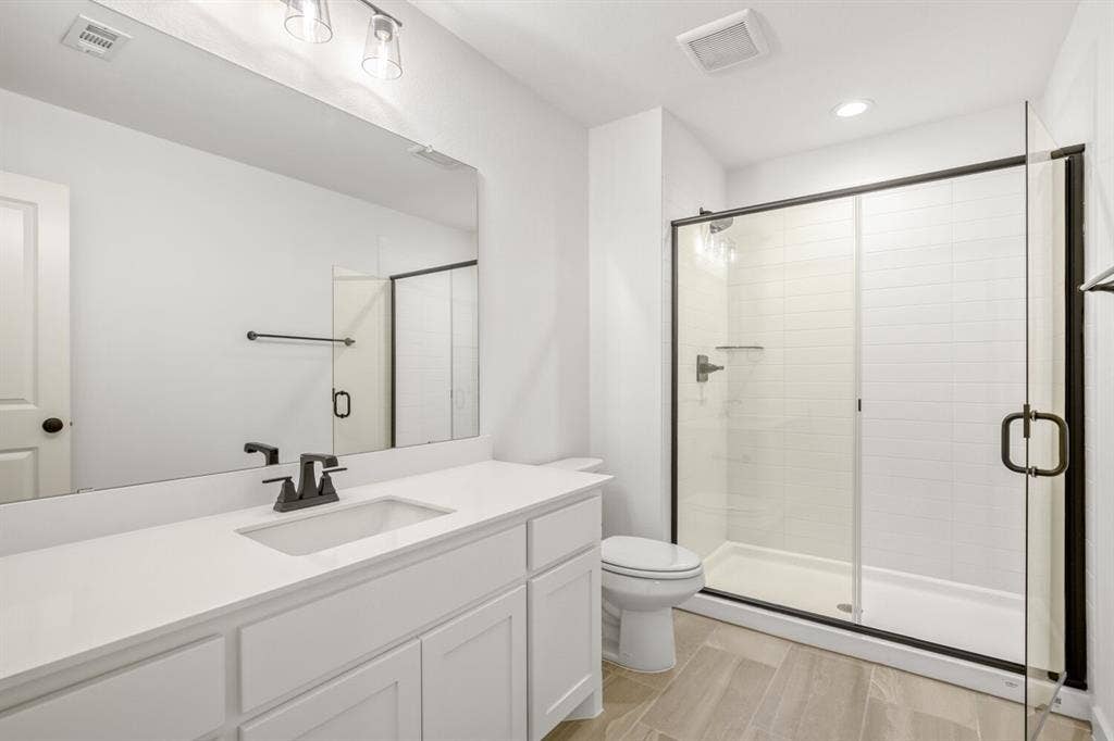 2228 Prickly Cactus Drive, Forney, TX 75126 Bathroom featuring a shower stall, vanity, wood tiled floors, and recessed lighting