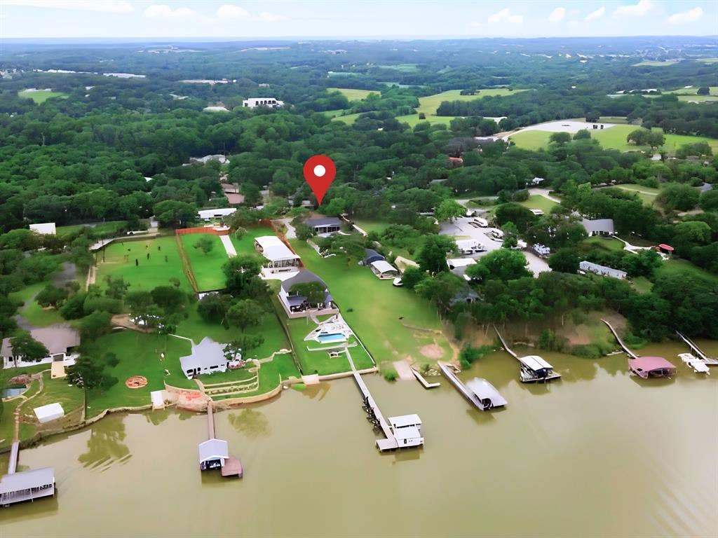 7130 Briar Road, Azle, TX 76020 Waterfront property featuring a private boat dock, expansive green lawn, and a swimming pool