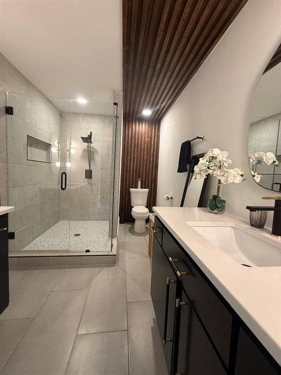 Full bathroom with vanity, a shower stall, and light tile patterned floors