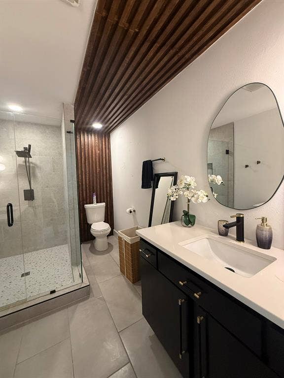 Bathroom featuring vanity, a stall shower, and light tile patterned flooring
