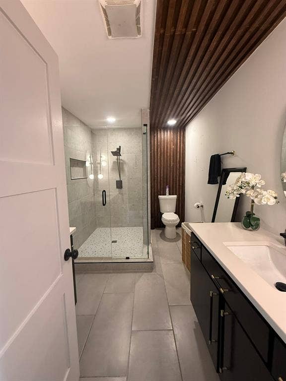 Bathroom with vanity, a shower stall, and light tile patterned floors