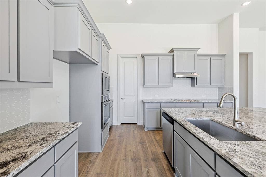 313 Trinity Court, Shady Shores, TX 76208 Kitchen featuring light wood-type flooring, gray cabinetry, light stone counters, decorative backsplash, and recessed lighting