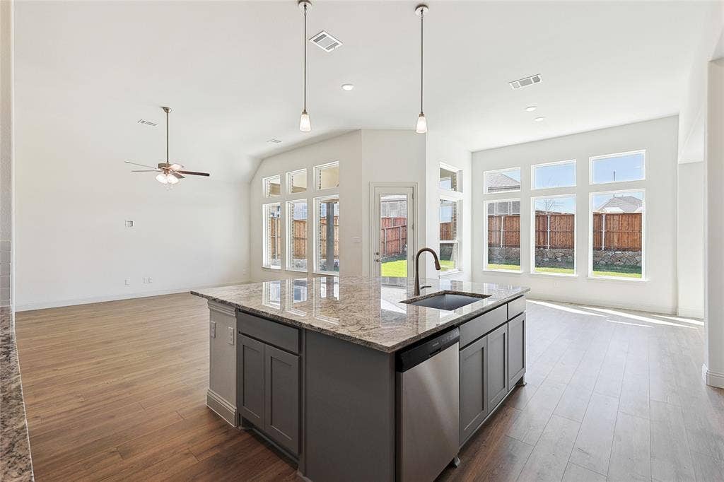 313 Trinity Court, Shady Shores, TX 76208 Kitchen with open floor plan, gray cabinets, an island with sink, dark wood-type flooring, and light stone countertops