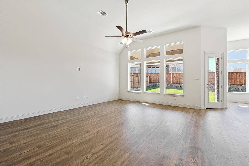 313 Trinity Court, Shady Shores, TX 76208 Unfurnished living room featuring wood finished floors, lofted ceiling, and a ceiling fan