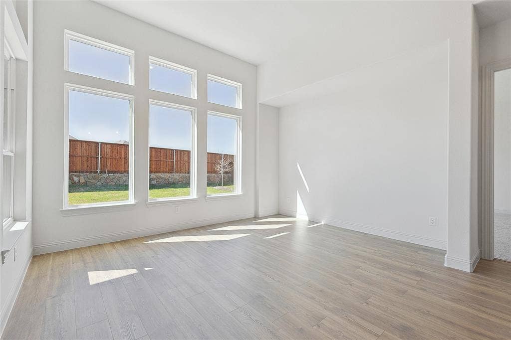 313 Trinity Court, Shady Shores, TX 76208 Unfurnished room with light wood finished floors and healthy amount of natural light