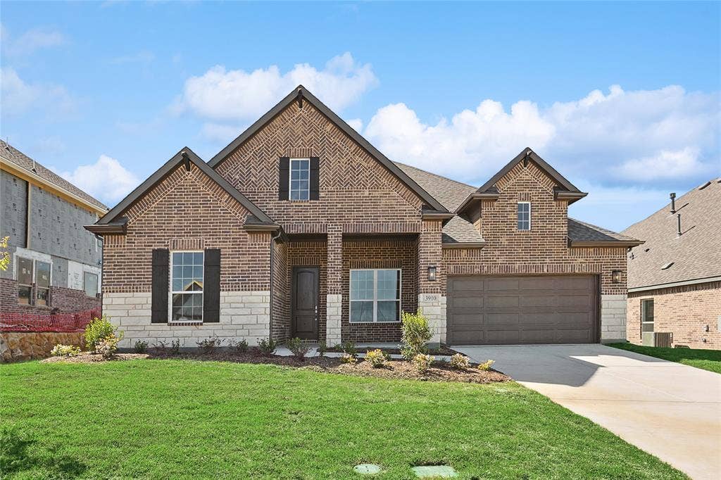 313 Trinity Court, Shady Shores, TX 76208 View of front facade featuring stone siding, brick siding, a front yard, concrete driveway, and roof with shingles