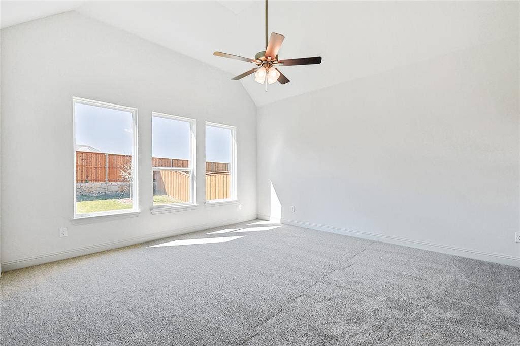 313 Trinity Court, Shady Shores, TX 76208 Carpeted spare room featuring vaulted ceiling and a ceiling fan