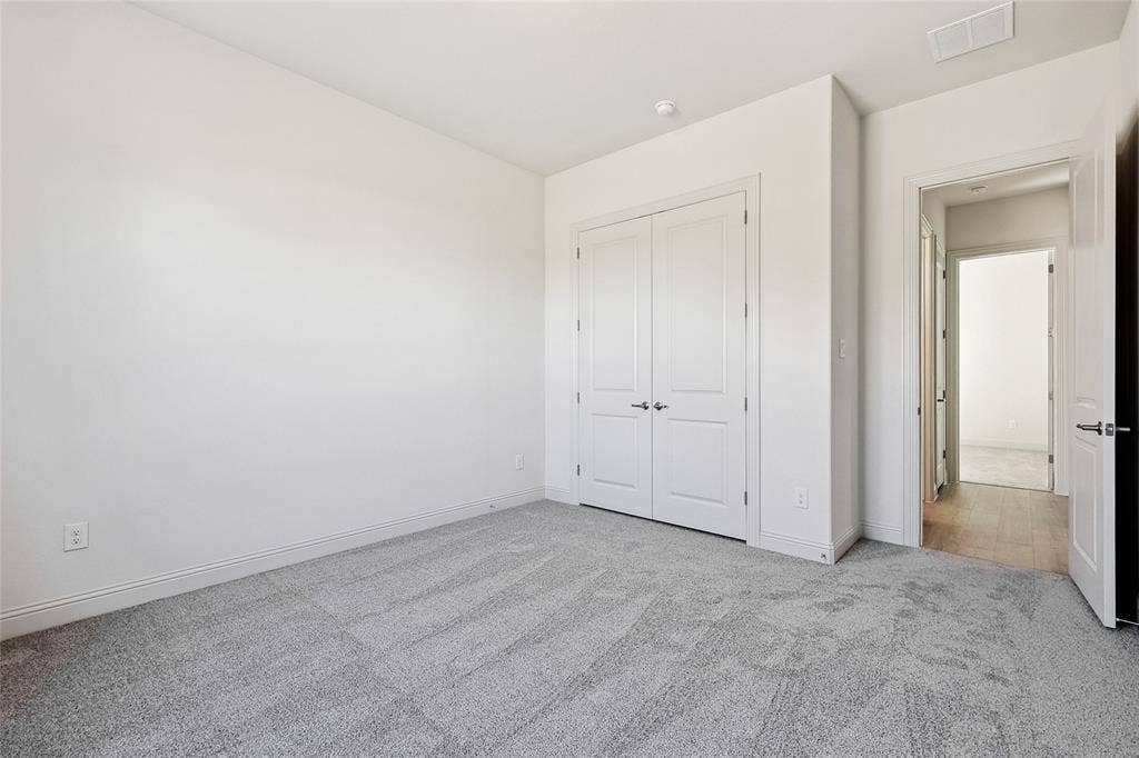 313 Trinity Court, Shady Shores, TX 76208 Unfurnished bedroom featuring light colored carpet and a closet