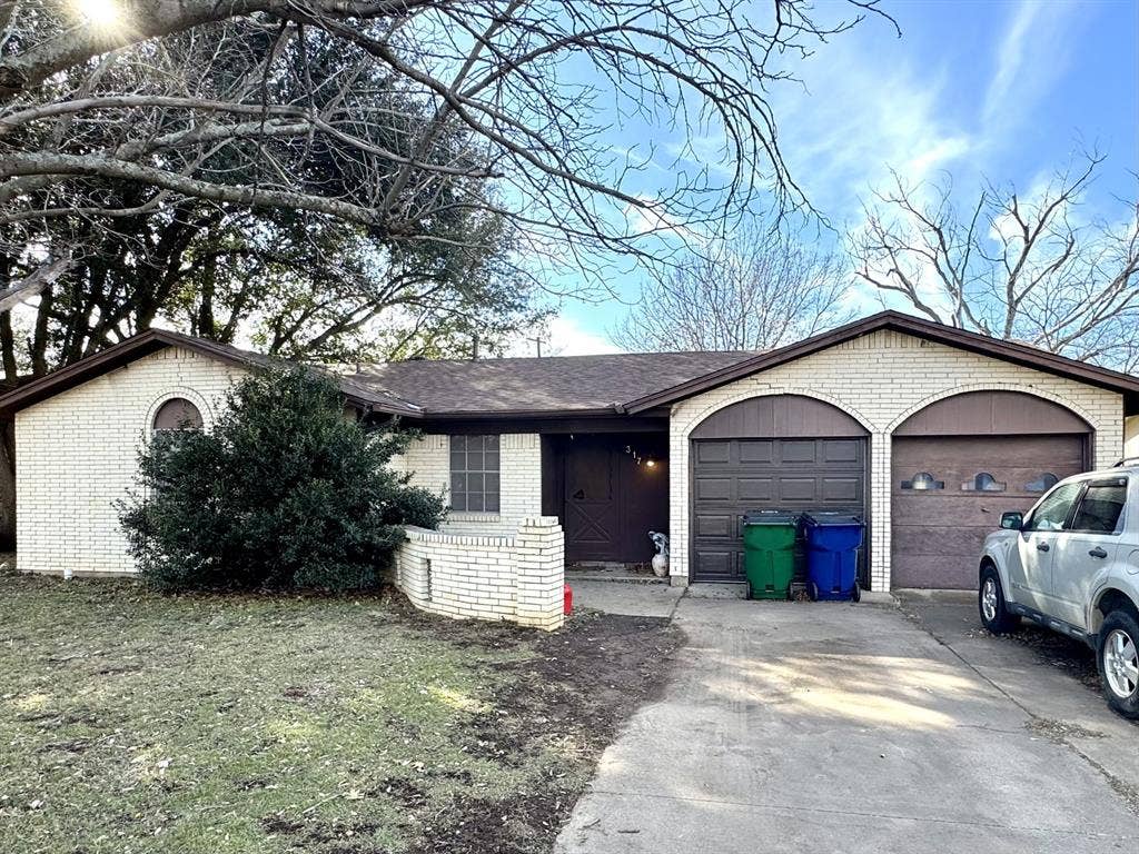 317 N Trail Street, Crowley, TX 76036 Ranch-style house with brick siding, driveway, and an attached garage