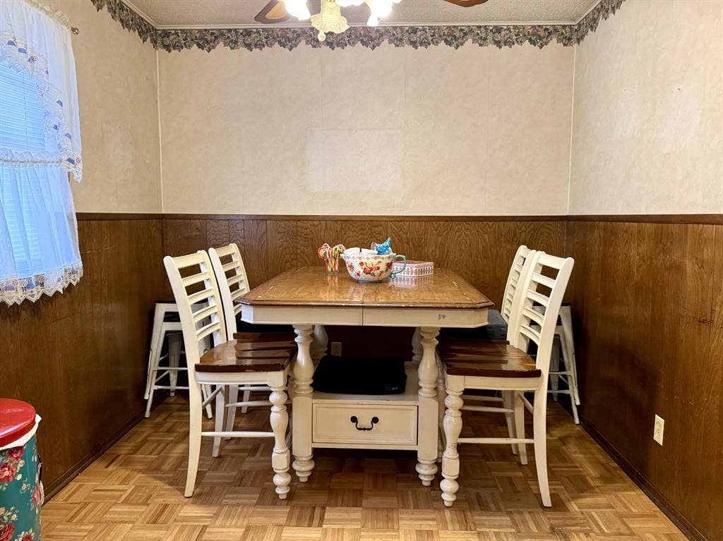 317 N Trail Street, Crowley, TX 76036 Dining space with wainscoting, wood walls, and ceiling fan
