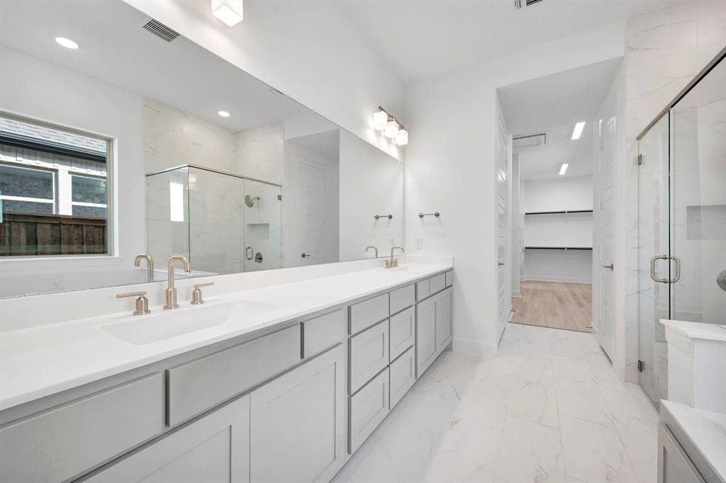 2079 Emerald Grove Lane, Arlington, TX 76005 Full bathroom featuring double vanity, a marble finish shower, a spacious closet, and light marble finish flooring