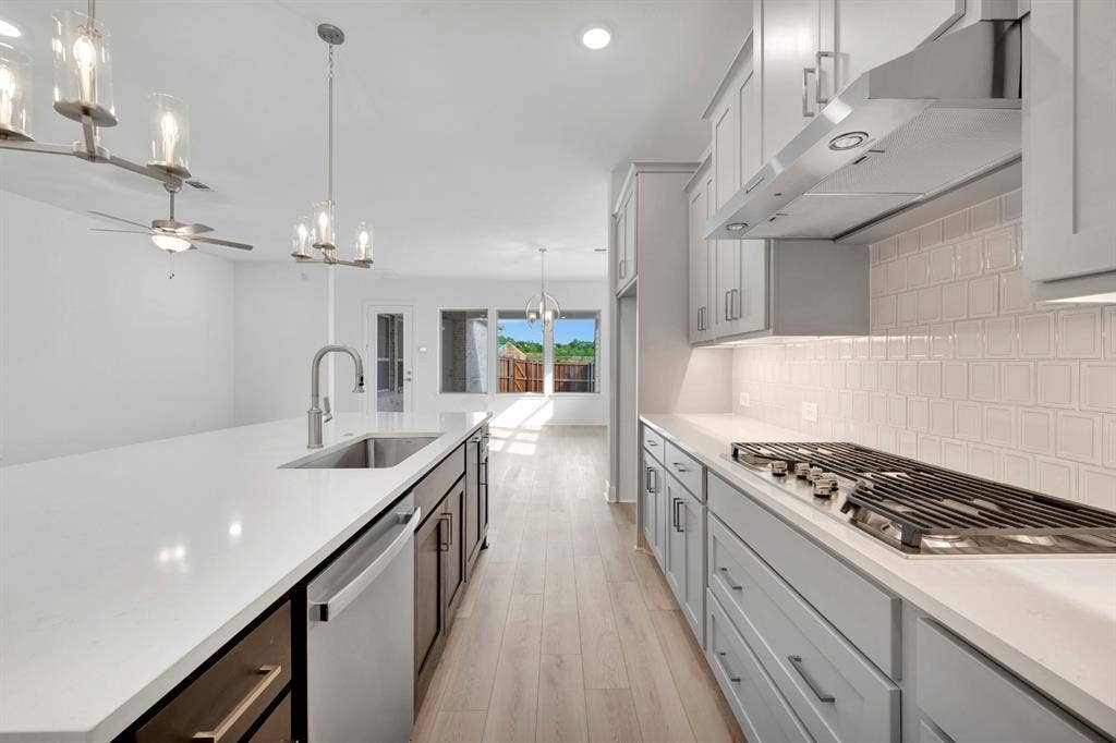 2079 Emerald Grove Lane, Arlington, TX 76005 Kitchen featuring hanging lights, a ceiling fan, stainless steel appliances, light wood-style flooring, and light stone counters