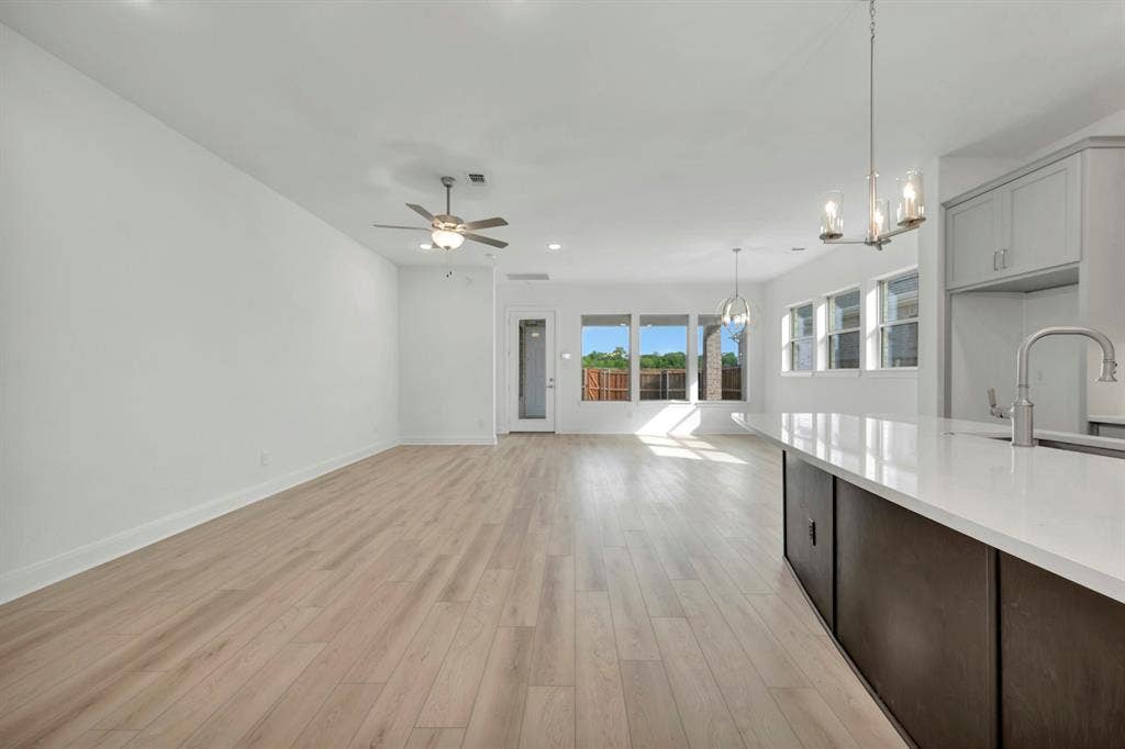 2079 Emerald Grove Lane, Arlington, TX 76005 Kitchen featuring open floor plan, light wood finished floors, hanging lights, ceiling fan, and dark wood finish cabinets