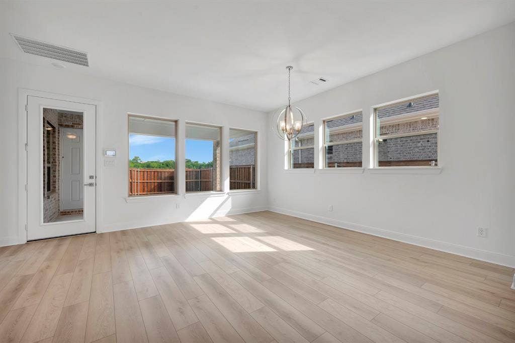 2079 Emerald Grove Lane, Arlington, TX 76005 Unfurnished room featuring a chandelier and light wood finished floors