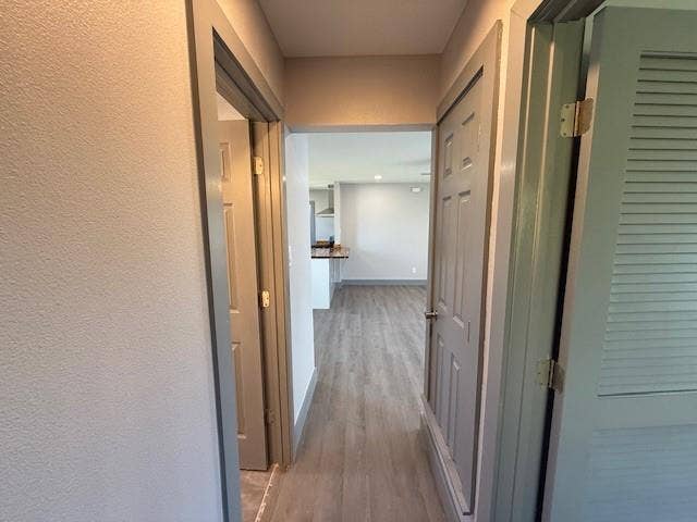 5845 Haney Drive, Watauga, TX 76148 Corridor featuring light wood-style flooring and a textured wall
