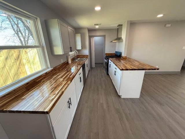 5845 Haney Drive, Watauga, TX 76148 Kitchen featuring a peninsula, butcher block counters, stainless steel appliances, dark wood-style flooring, and recessed lighting