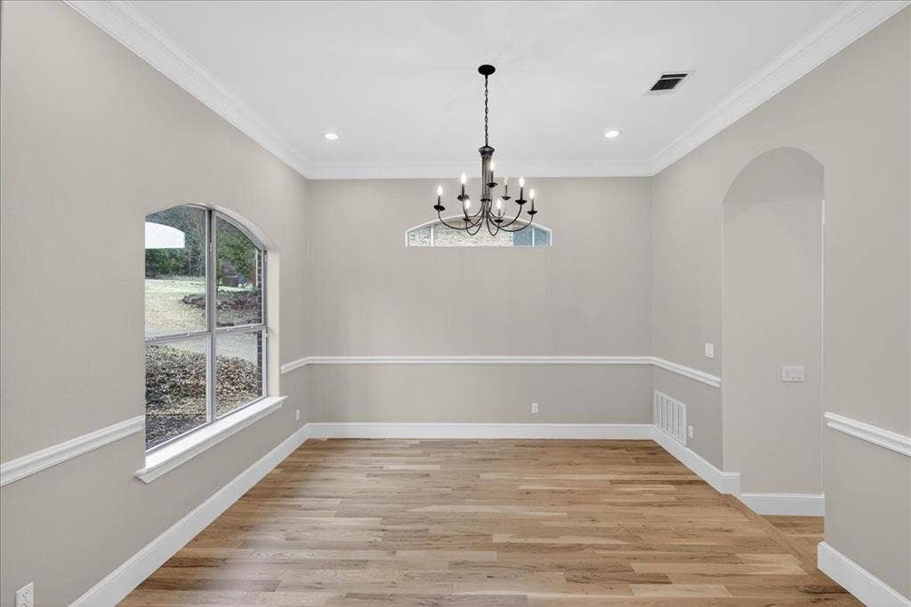 5182 Bayshore Drive, Athens, TX 75752 Unfurnished dining area featuring light wood finished floors, suspended lighting, and ornamental molding