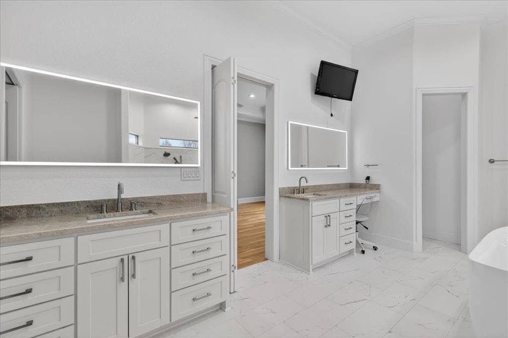5182 Bayshore Drive, Athens, TX 75752 Full bathroom with light marble finish floors, ornamental molding, two vanities, and a soaking tub