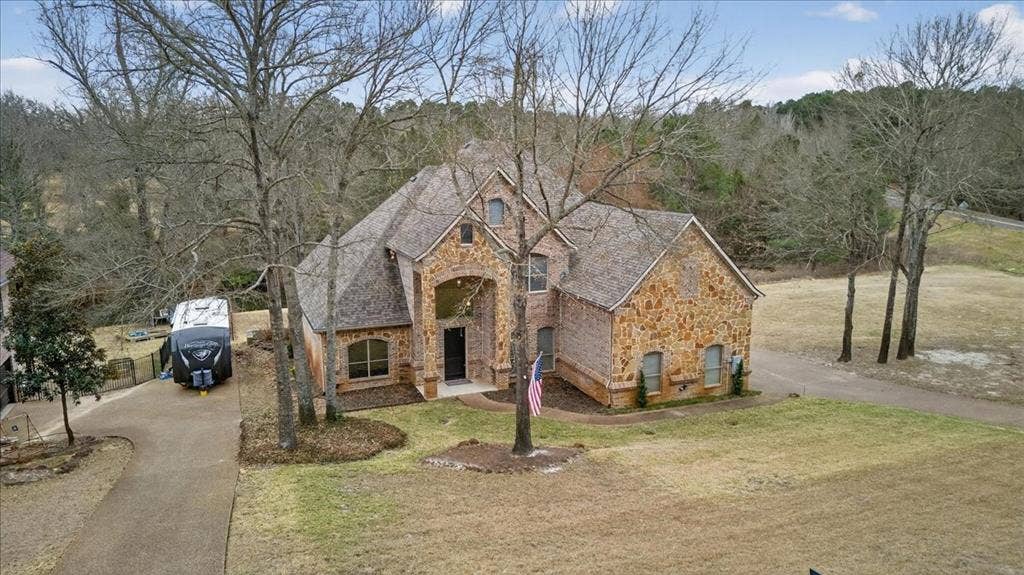 5182 Bayshore Drive, Athens, TX 75752 French country home featuring stone siding, driveway, brick siding, and a front lawn