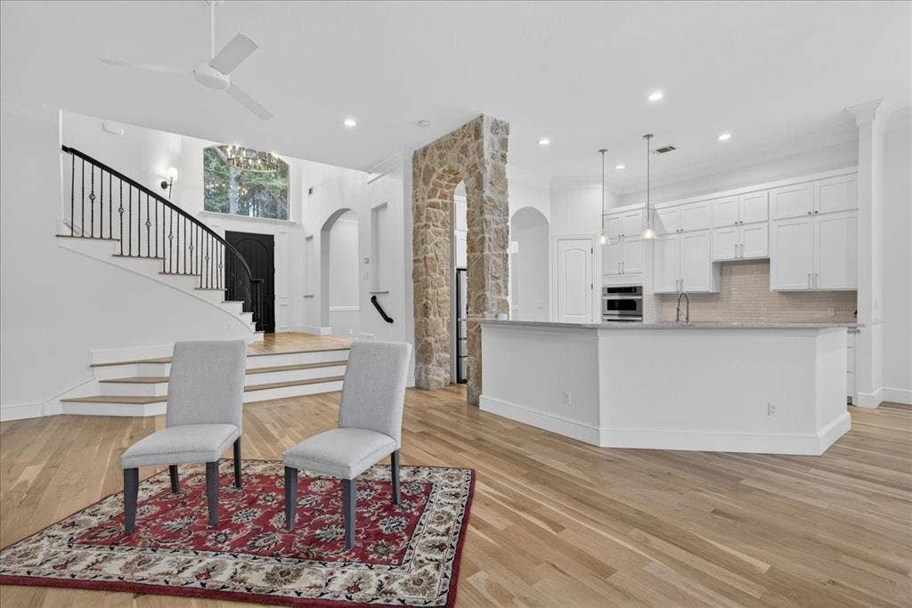 5182 Bayshore Drive, Athens, TX 75752 Kitchen with arched walkways, white cabinets, light wood finished floors, hanging light fixtures, and a ceiling fan