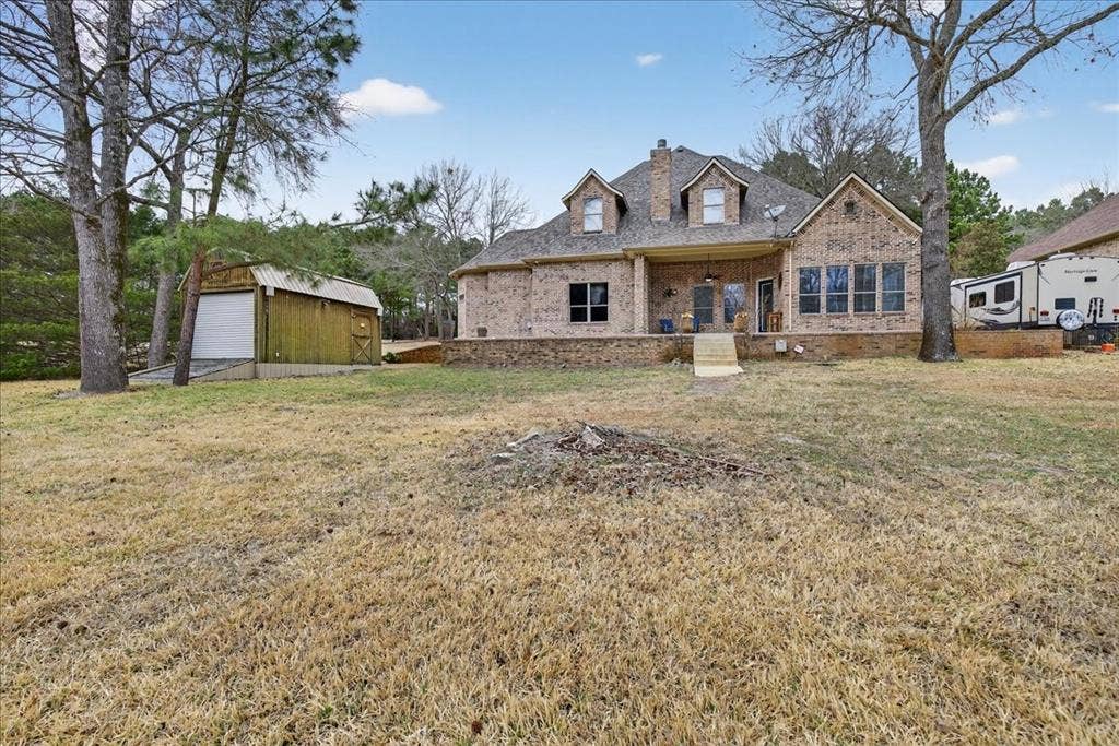 5182 Bayshore Drive, Athens, TX 75752 View of front of house with covered porch, a front lawn, an outbuilding, and brick siding